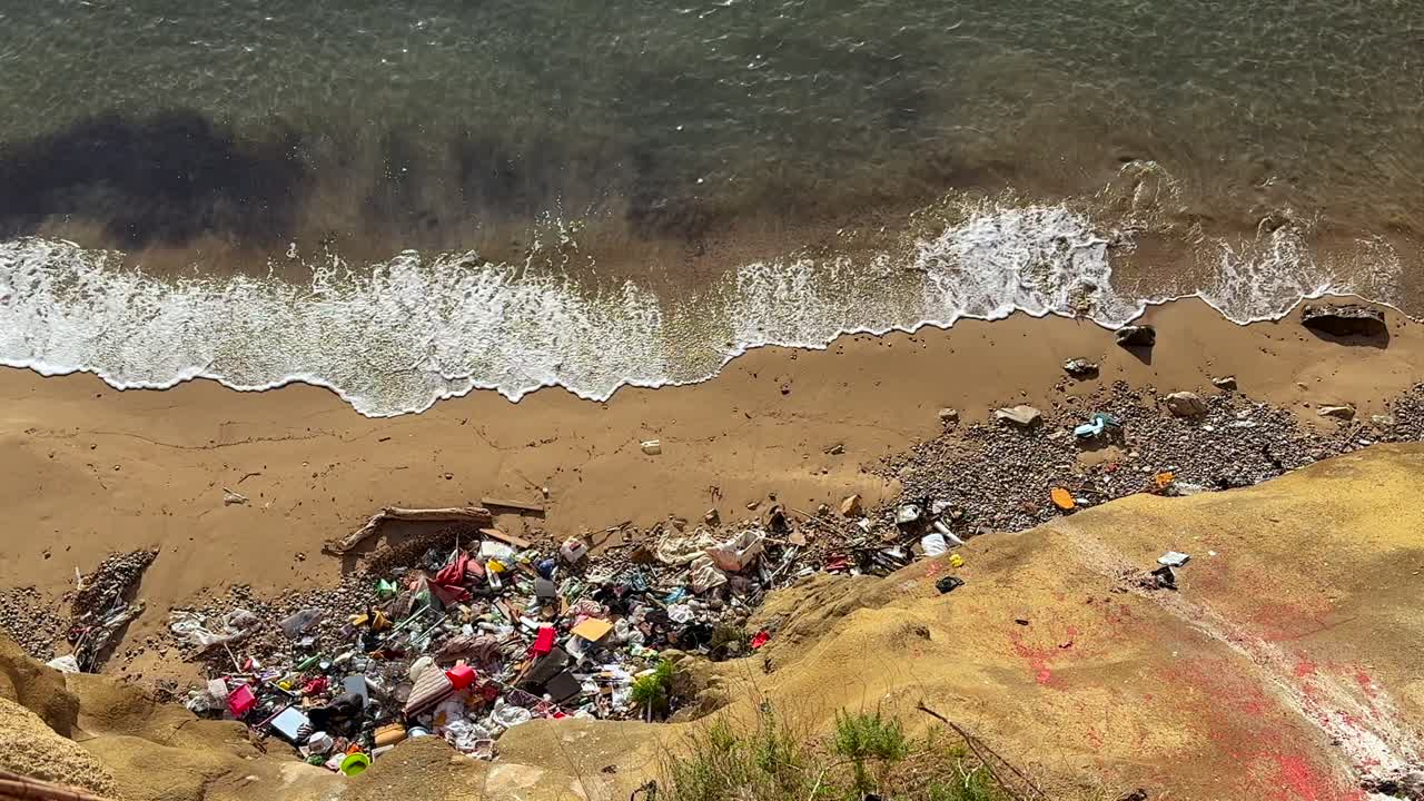 high-angle shot of a paradisiacal beach with pristine sea water. full of trash in Ibiza island