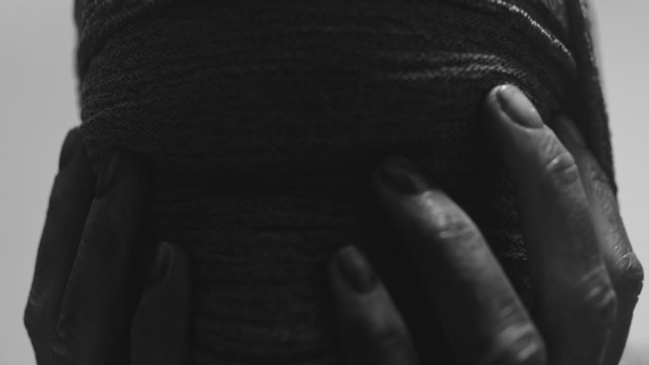 A mummified woman against the bright background in keeps her hands on her face the powerful pose full of despair