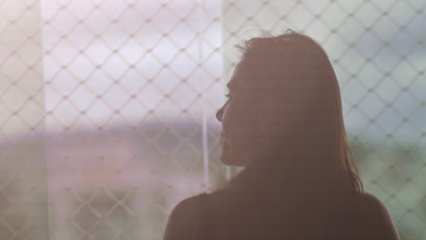 back of brunette woman admiring view outside apartment window, slow motion