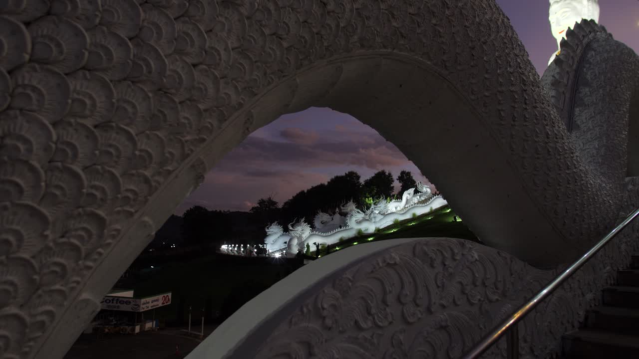 Creative framed view of the Guan Yin statue and dragon stairway at Wat Huay Pla Kang Buddhist temple in Chiang Rai, Thailand