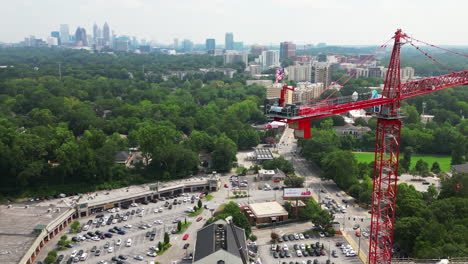 Aerial-view-of-tall-tower-crane-with-fluttering-American-flag-on-top