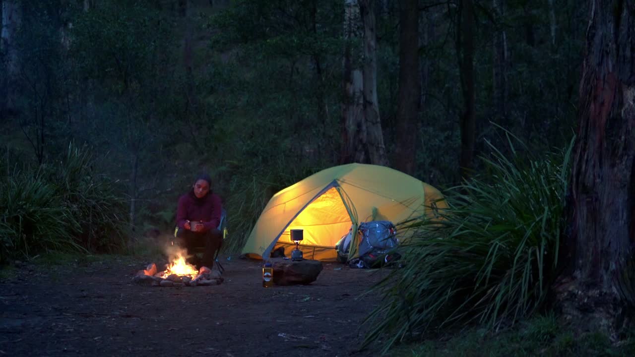 mochilero indígena australiano sentado junto al fuego en el parque nacional de las montañas azules