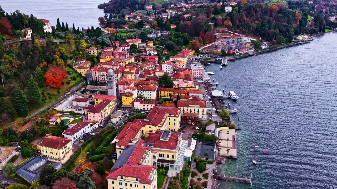 Vista aerea di Bellagio sul Lago di Como, che mette in mostra colorati edifici sul lago, stradine strette e il lungomare circondato da vivaci alberi autunnali