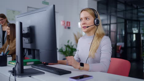 mujer trabajando en la computadora con auriculares