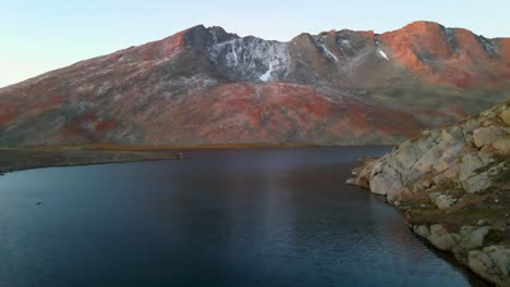 Incredible-orange-reflection-of-the-sunset-in-the-mountains-next-to-a-calm-lake