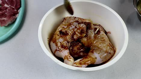 cuchareando la marinada sobre las patas de pollo