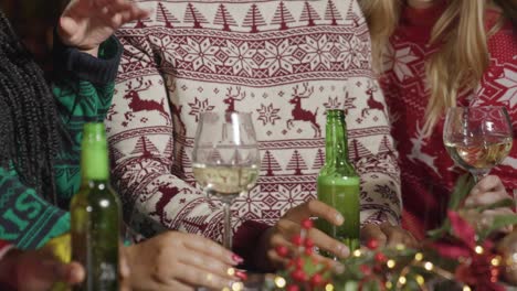 close up of friends celebrating christmas at bar