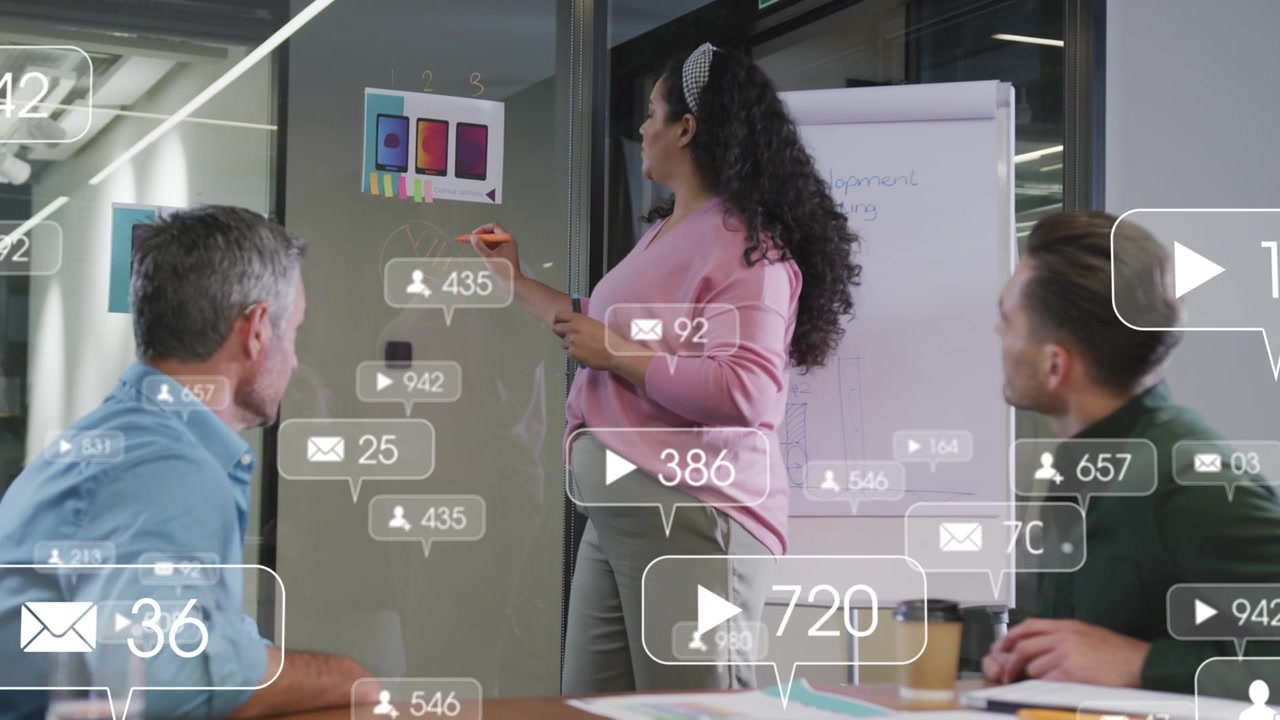Woman leading meeting pointing to mockups and writing on glass activating overlays for marketing