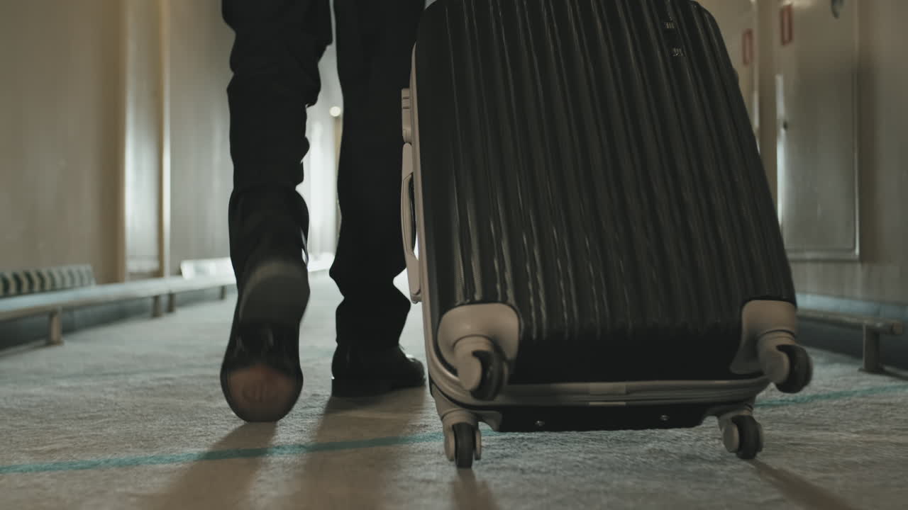 Legs of Businessman Carrying Suitcase in Hotel