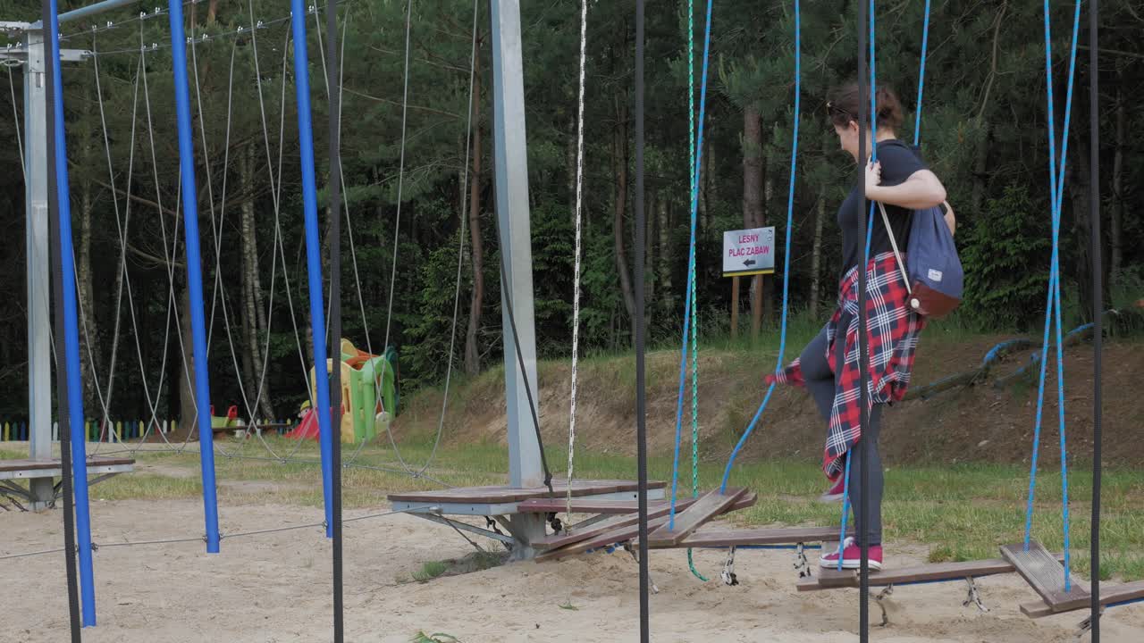 женщина-туристка развлекается на висячем мосту в казубском парке гигантов в польше - широко