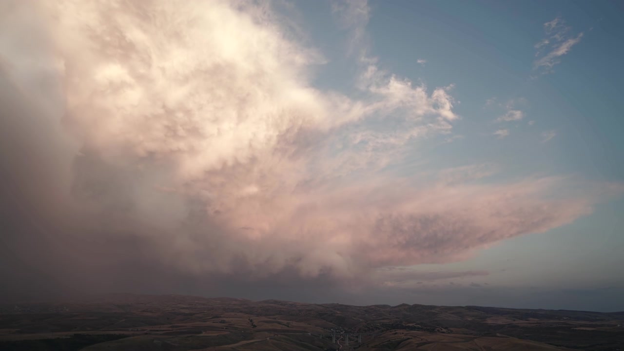 Time Lapse of Storm Clouds Moving Over Rolling Landscape
