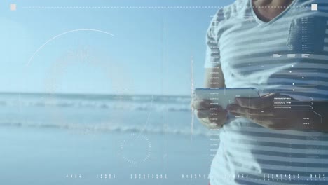 animation of data processing over happy caucasian man using tablet at beach