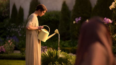 a woman watering plants in a lush garden