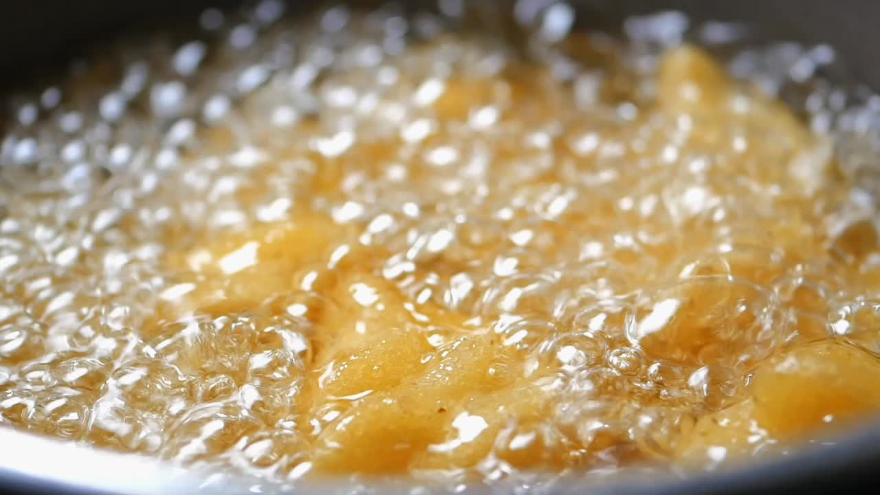 Frittura profonda di alimenti dorati in olio caldo e ribollente