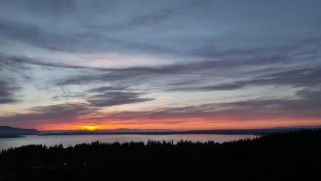 Toma-Aérea-Del-Bosque-Del-Arboreto-De-La-Colina-Sehome-Con-Vistas-A-La-Puesta-De-Sol-Sobre-La-Bahía-De-Bellingham