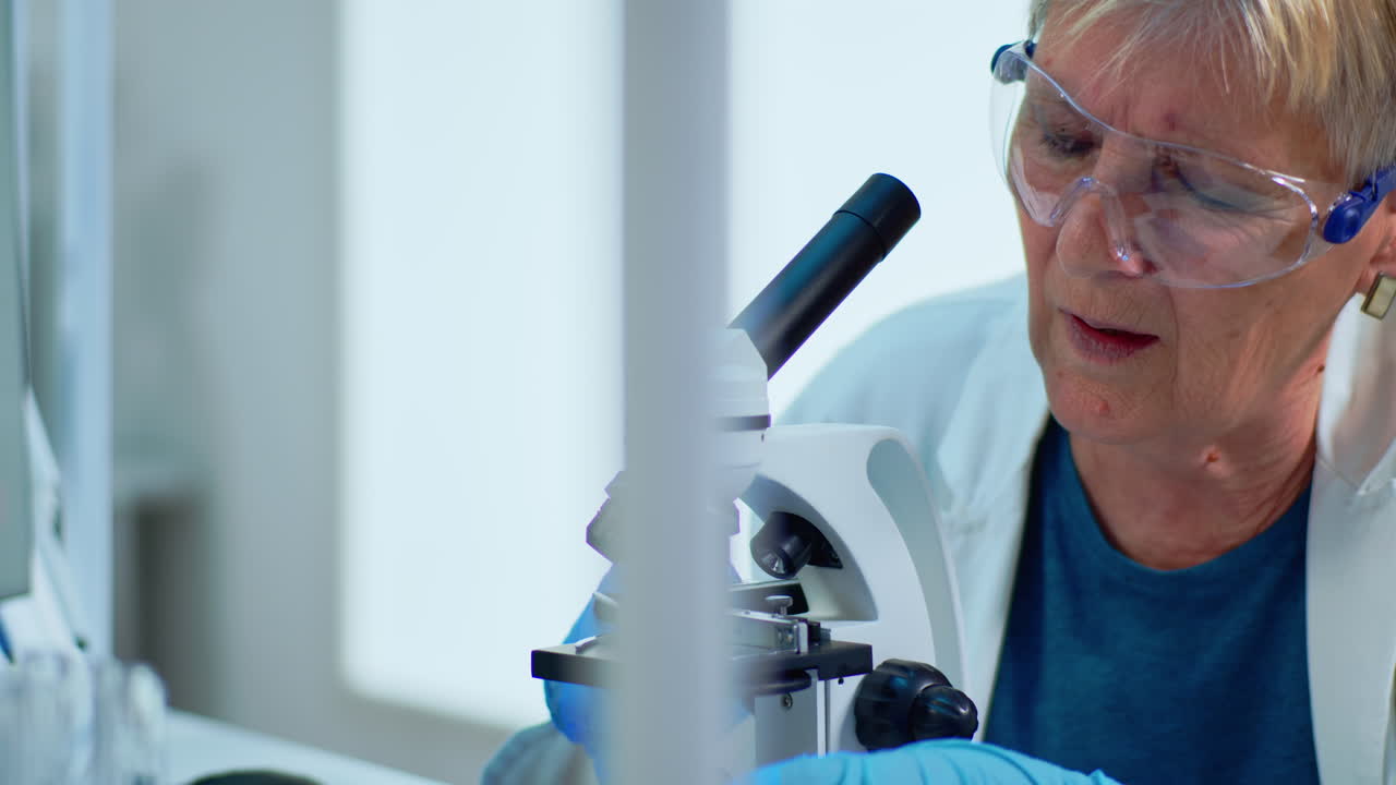 Close up of woman research scientist looking at samples under microscope