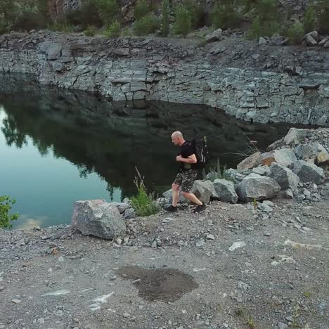 aerial view of a tourist walks along the rocky shore of a lake. traveler on the cliff. camping season