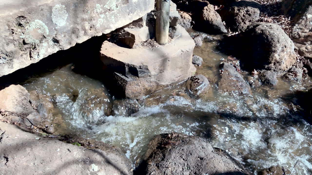 seguimiento panorámico del agua del arroyo que fluye desde la cascada hasta el estanque, ju raku en el jardín japonés, toowoomba, australia