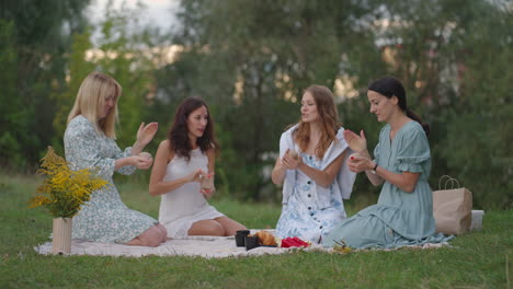 un grupo de mujeres jóvenes en la naturaleza llevan a cabo una clase magistral en el modelado de arcilla. actividades conjuntas comunicación risa un pasatiempo común un círculo de mujeres.