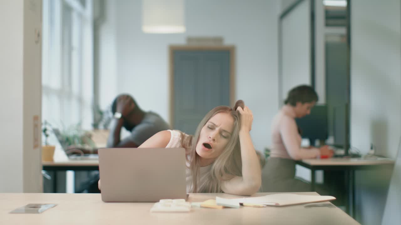 Tired woman sleeping with notebook at coworking office