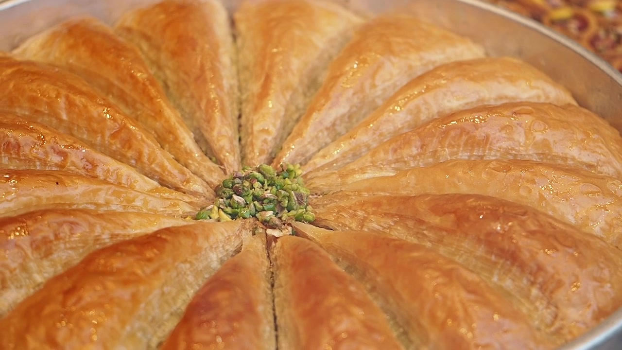 Close-up of Traditional Turkish Baklava with Pistachios in a Round Tray