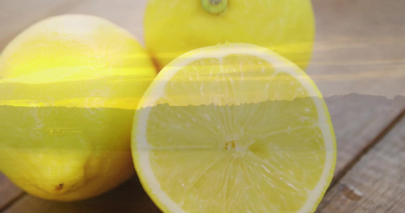 Primo piano iniziale di una fetta di limone tagliata a metà, con scie di luce che fluttuano mentre la telecamera si allontana rivelando due limoni.