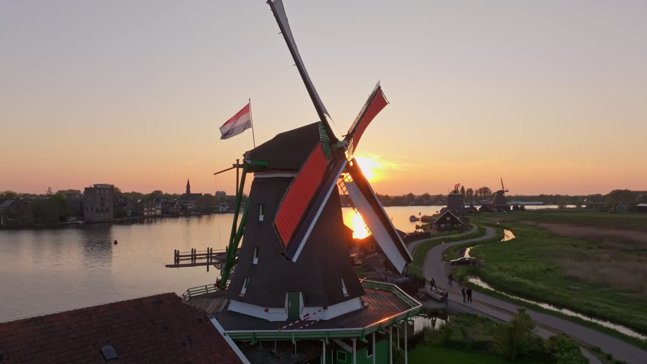 Vista aerea del cielo tinto di arancione sopra i mulini di Zaanse Schans nel Giorno del Re.
