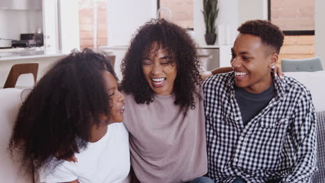 Junge-Erwachsene-Und-Schwarze-Teenager-Geschwister,-Die-Zusammen-Lachen-Und-Zu-Hause-Auf-Einem-Sofa-Sitzen,-Aus-Nächster-Nähe