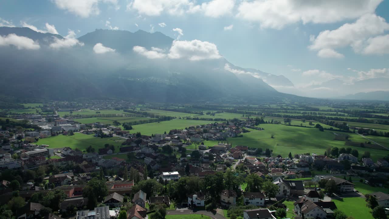 vista aérea de liechtenstein con casas en campos verdes en el valle de las montañas de los alpes