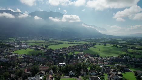 luftaufnahme von liechtenstein mit häusern auf grünen feldern im alpen-bergtal