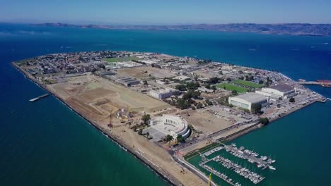 4k aerial drone view of treasure island san francisco bay area surrounded by turquoise blue ocean sea water waves camera move forward