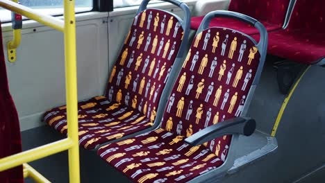 close up of red bus seats with a pattern of stick figures