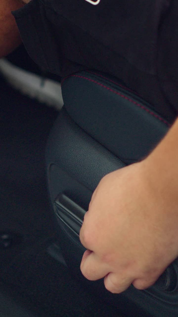 Mano ajustando la palanca del asiento de coche en el interior de un vehículo