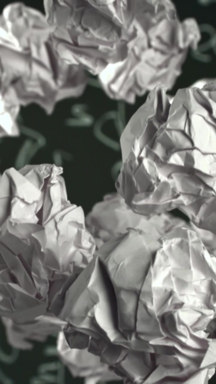Papier froissé s'élevant contre un tableau noir avec des équations mathématiques