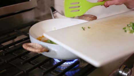 Mujer-Agregando-Ají-A-La-Sartén-De-Cocinar-Verduras-En-Cámara-Lenta