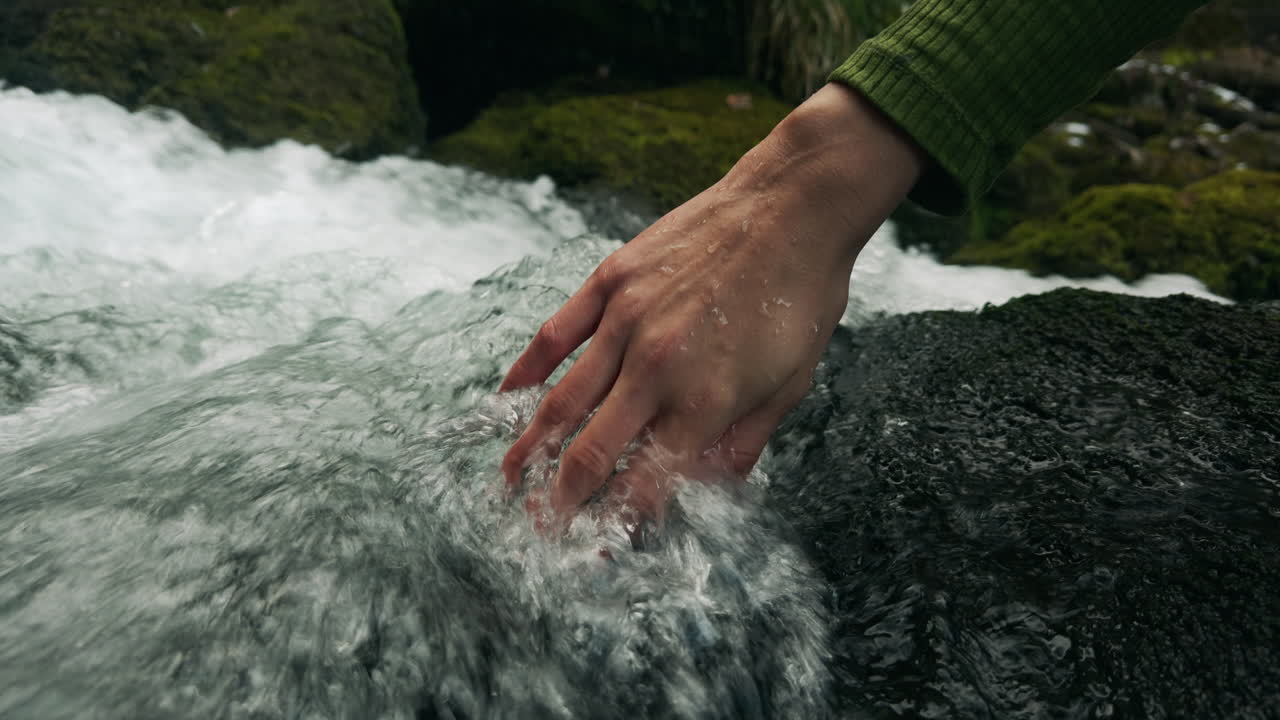 Mano in un torrente di montagna