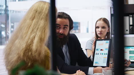 financial advisor showing statistical graphs on tablet to clients