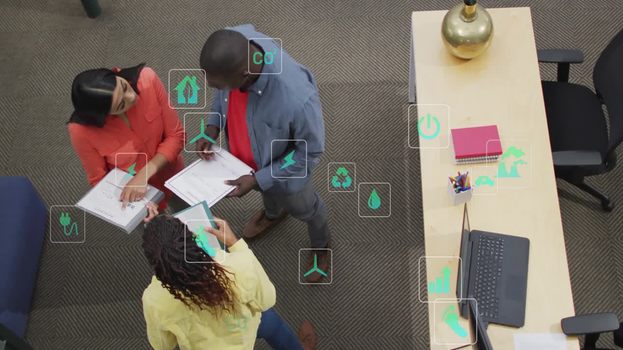 Three colleagues reading brochures and tablet activating sustainability icons showing metrics