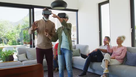 happy senior diverse people using vr headsets at retirement home