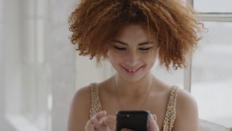 portrait of beautiful young woman using smartphone texting reading messages enjoying mobile phone communication mixed race female afro hairstyle