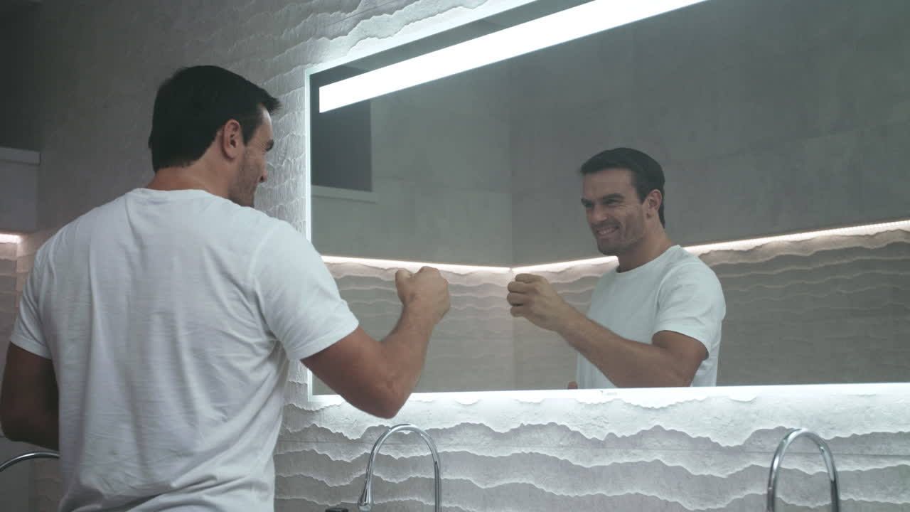 남자는 성공적인 하루를 위해 자신을 동기부여합니다. 섹시한 사람은 긍정적인 하루를 준비합니다.