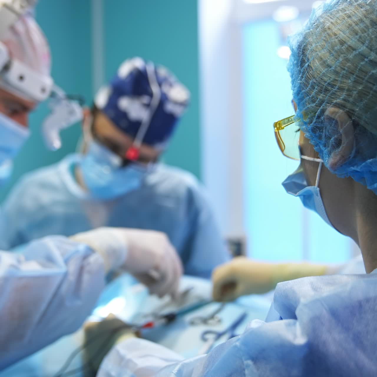 Female nurse in cap, mask and glasses preparing tool for doctors' usage. Woman cleans the used instruments with sponge