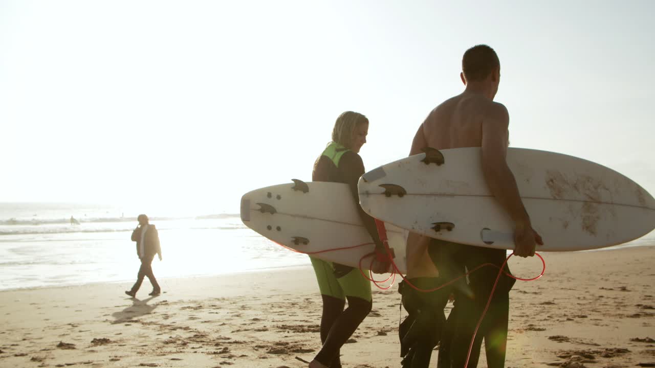 familia feliz con tablas de surf caminando por la playa