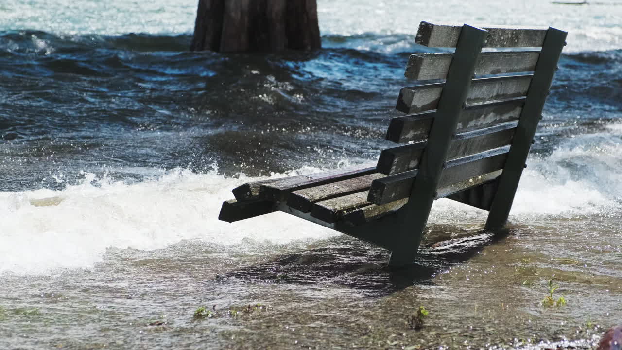 Waves from flooding on Park Bench In Flood Waters