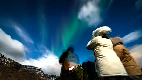 timelapse of tourists taking pictures and staring in wonder at northern lights