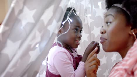 Happy-african-american-mother-and-daughter-talking-in-tent-at-home,-slow-motion