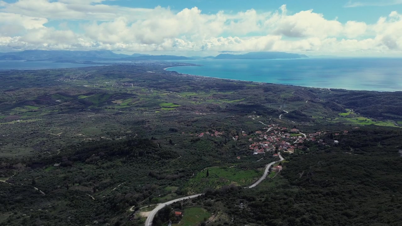 Mozzafiato panorama 4K con drone dall'antica Kassope sul Monte Zalongo. Rivelando il villaggio di Kamarina, colline verdi, strade di montagna tortuose e il vasto Mar Ionio blu in Epiro, Grecia