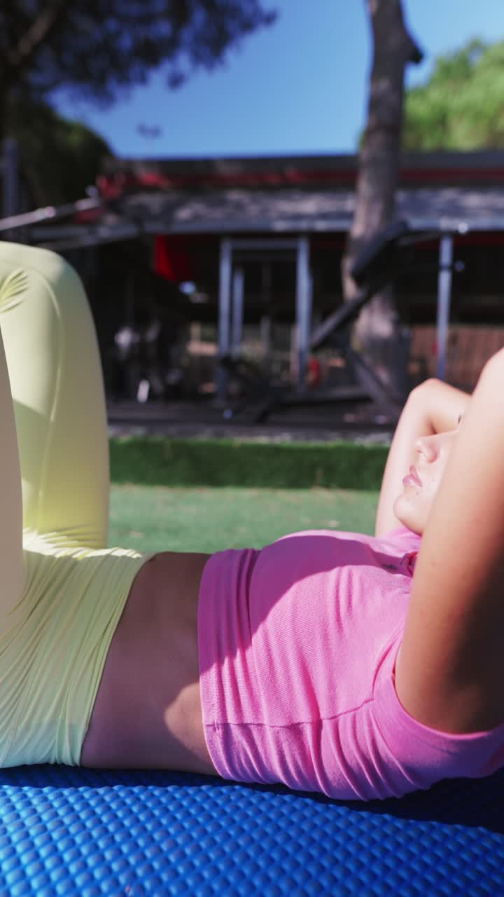 Woman exercising outdoors on a mat