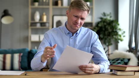 hombre de negocios molesto después de leer documentos en el trabajo