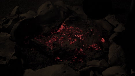 slow motion of campfire in stone fire pit being put out with sand and bucket